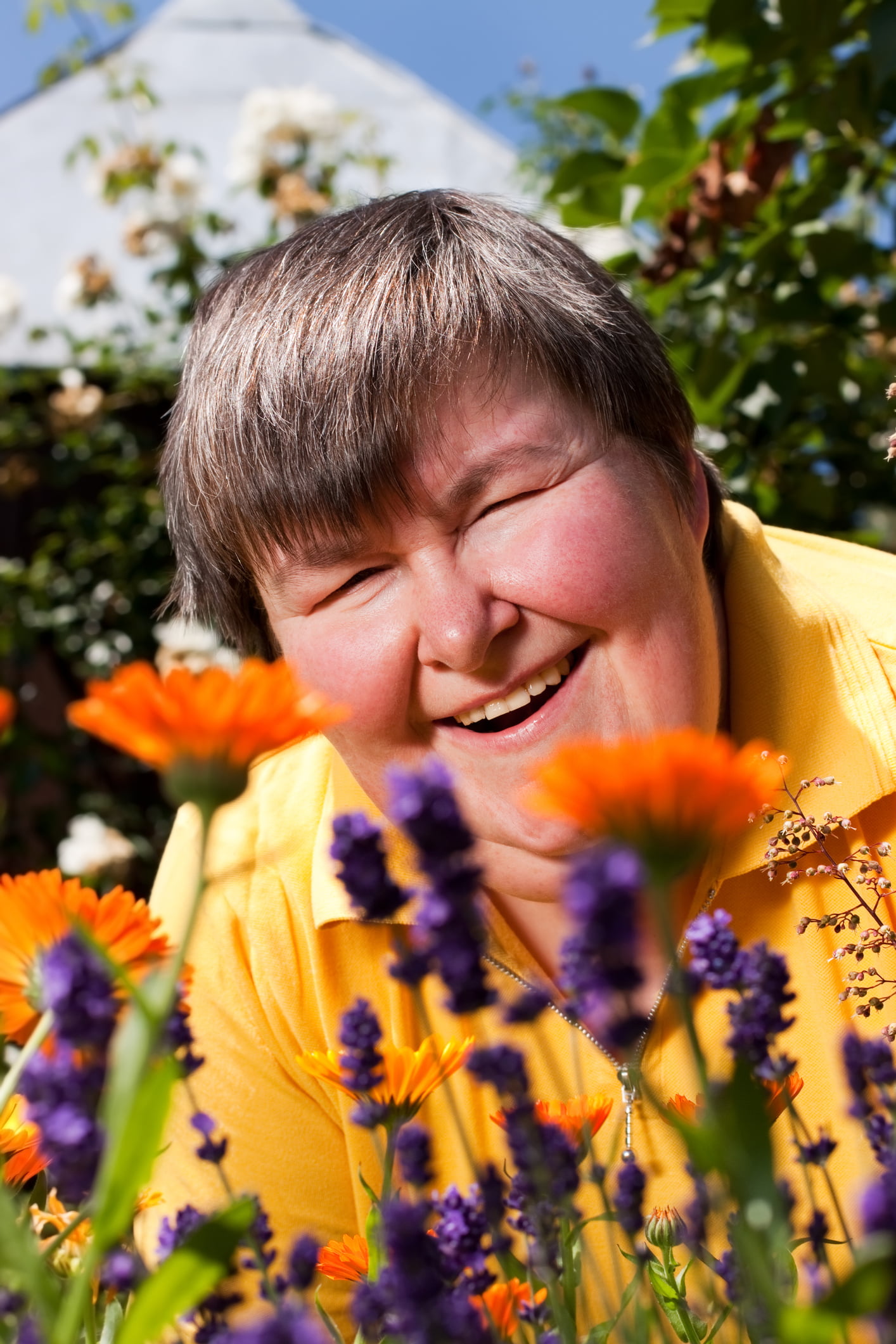 Smiling disabled woman appreciating flowers.